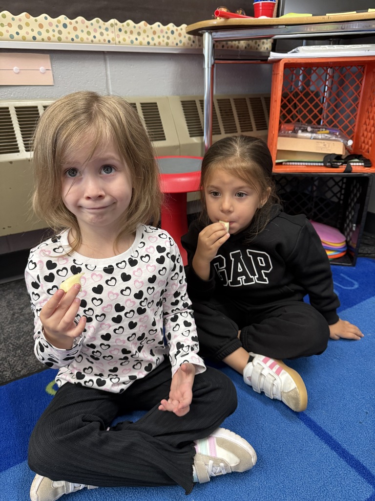 two students eating apple slices