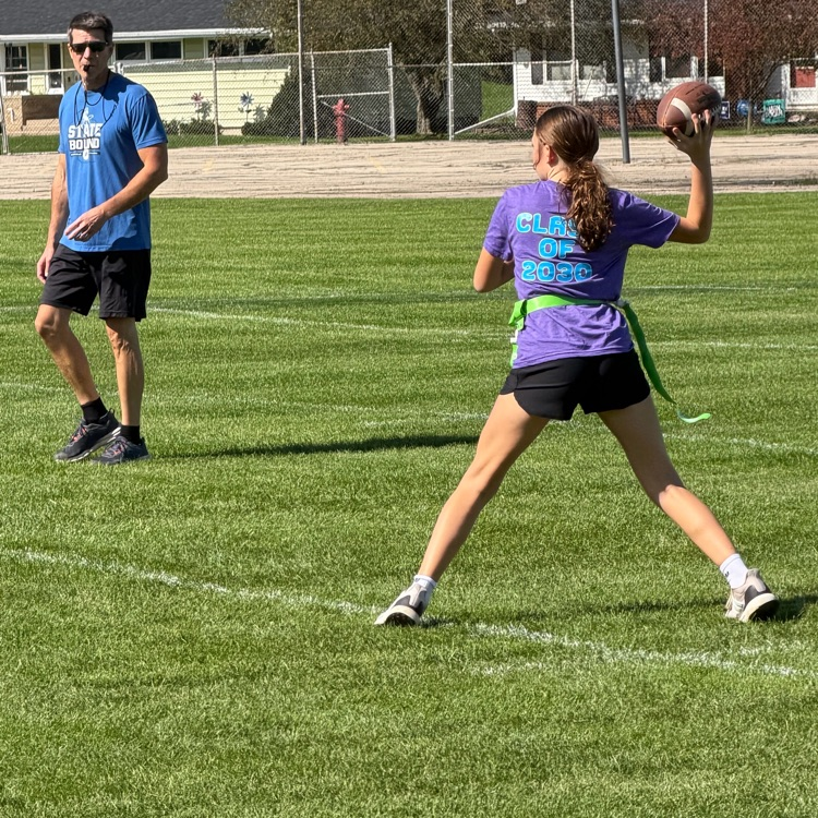 student throwing football and referee