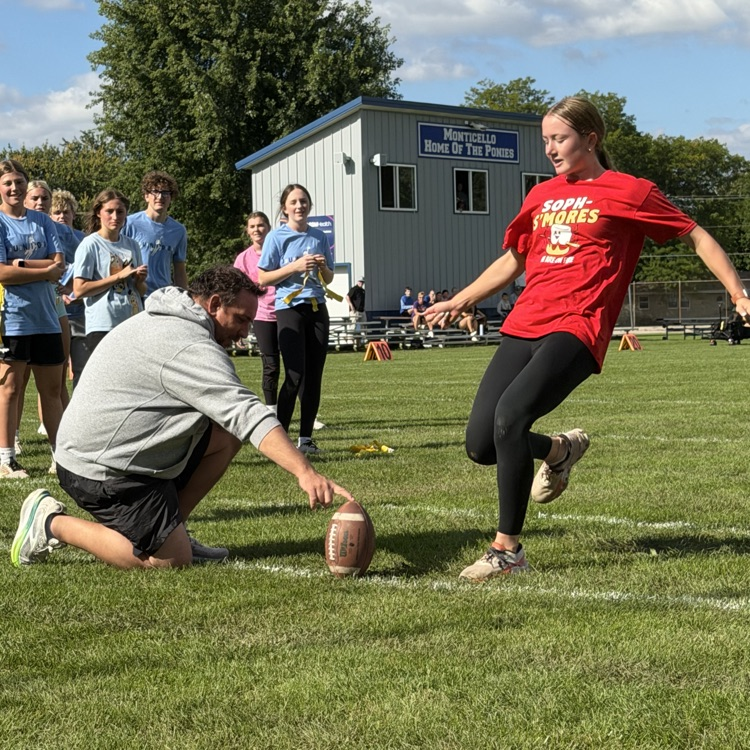student kicking football