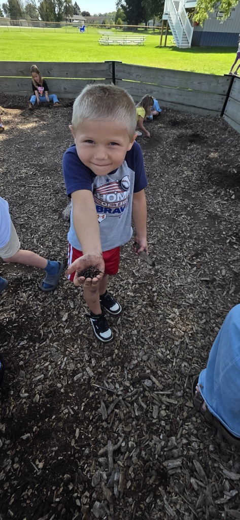 student holding dirt and a worm
