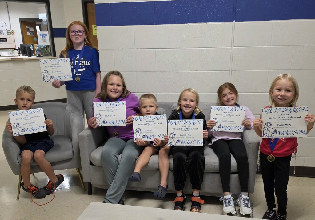 students of the month smiling and holding certificates
