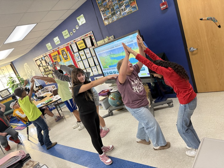 Middle school students making a mountain range in charades.