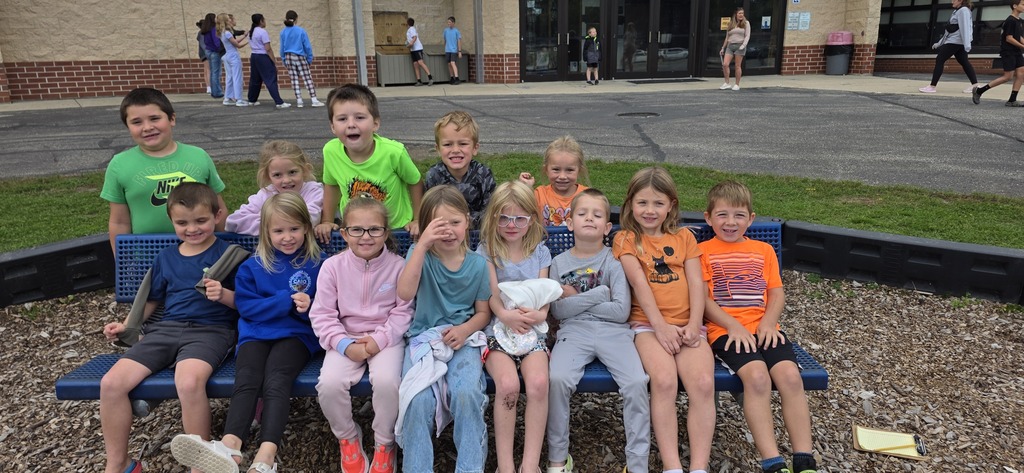 Group of children sitting on a bench.