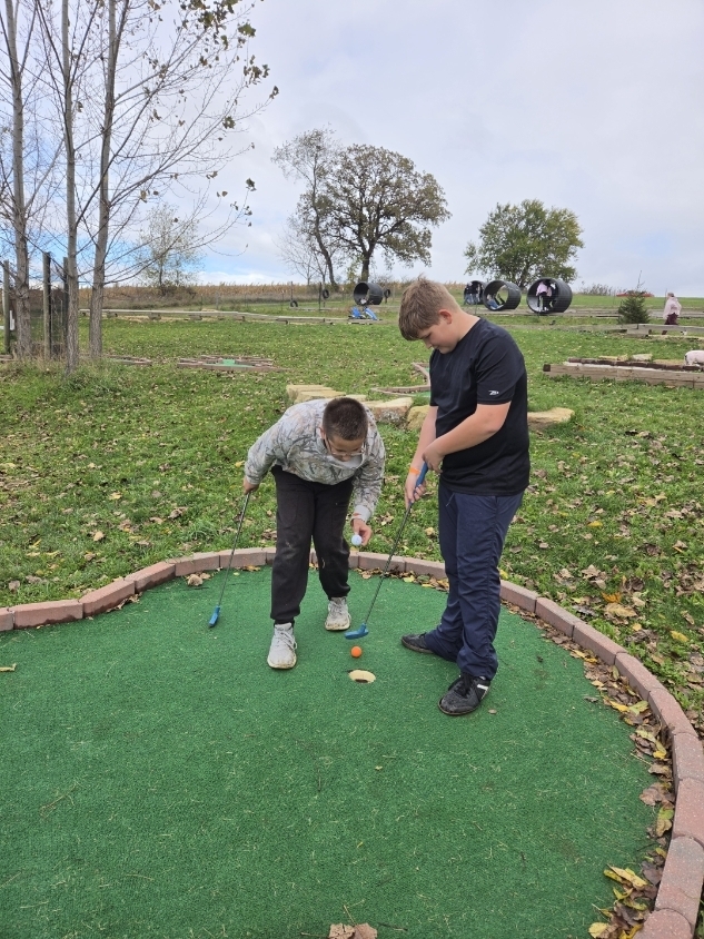Two boys mini golfing.