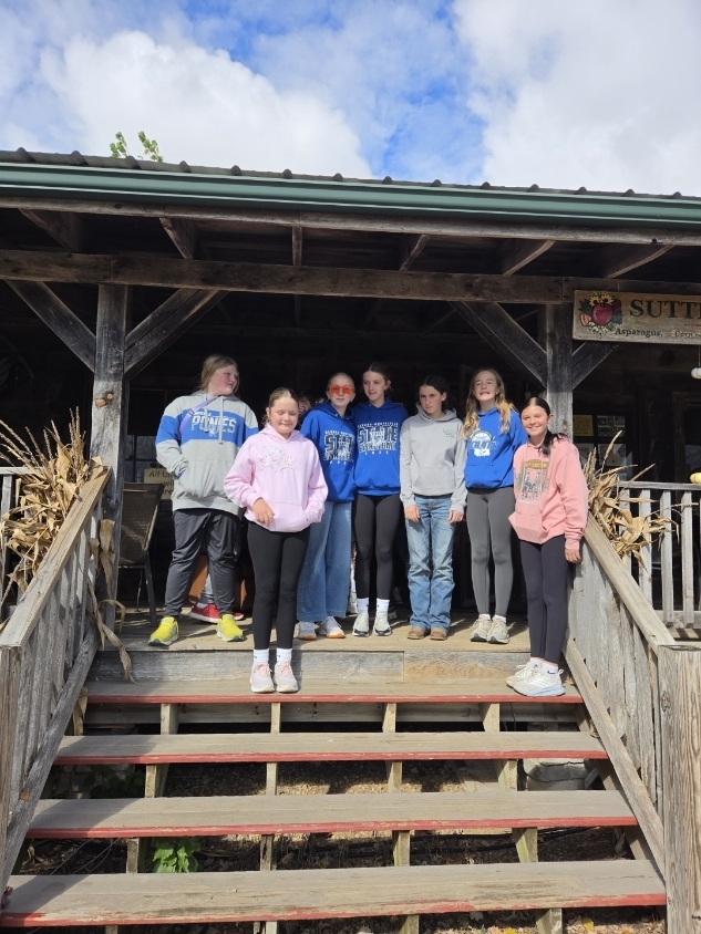 Students standing on a porch.