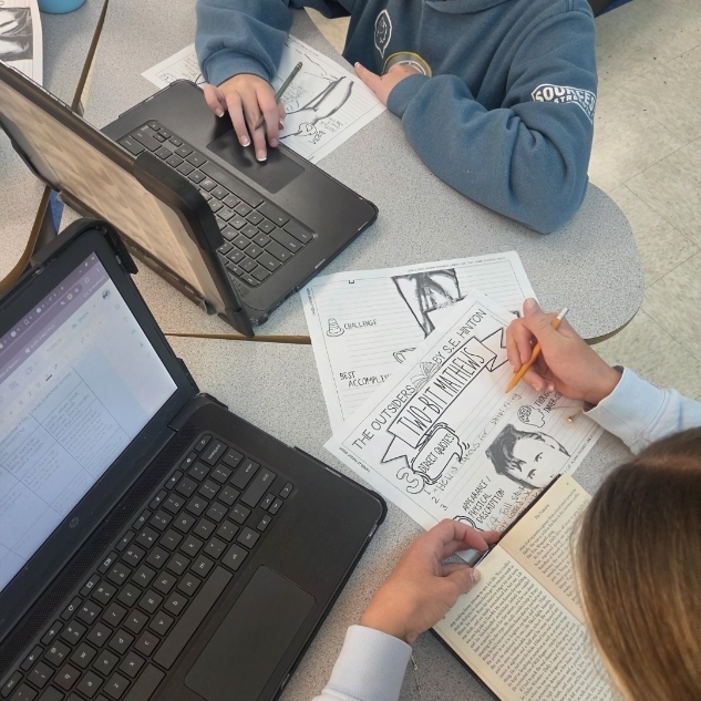 Students working on a character poster for the book, The Outsiders.