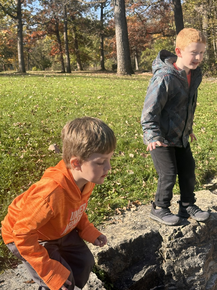 Two students standing on a rock wall.