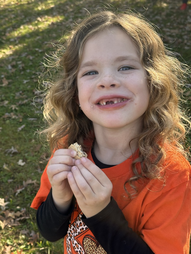 Student smiling and holding a s'more.