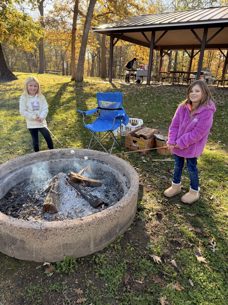 Two children roasting marshmallows.