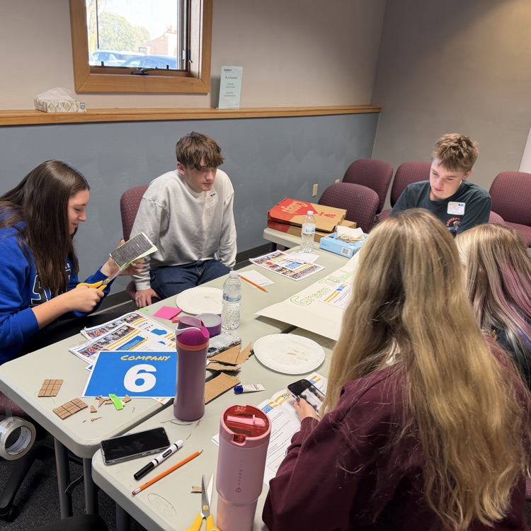 FBLA students creating a solar phone with paper, plates, and cardboard.