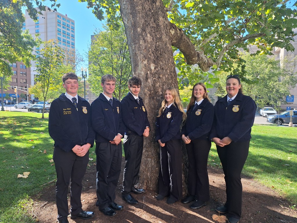 Monticello FFA members in official dress, standing by a tree.