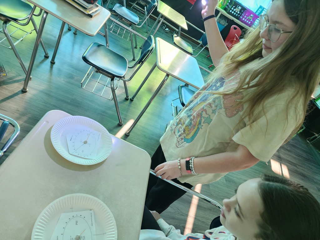 Students are exploring how the position of light affects the time shown on the clock.