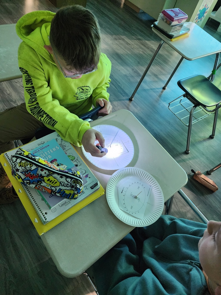 Students are exploring how the position of light affects the time shown on the clock.