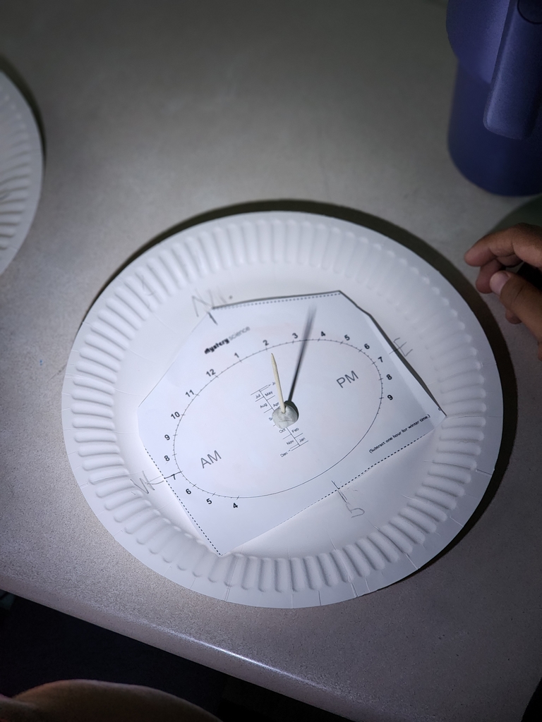 Students are exploring how the position of light affects the time shown on the clock.