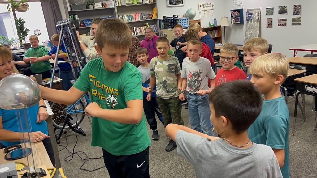Touching the Van de Graaff machine and discharging the static electricity.