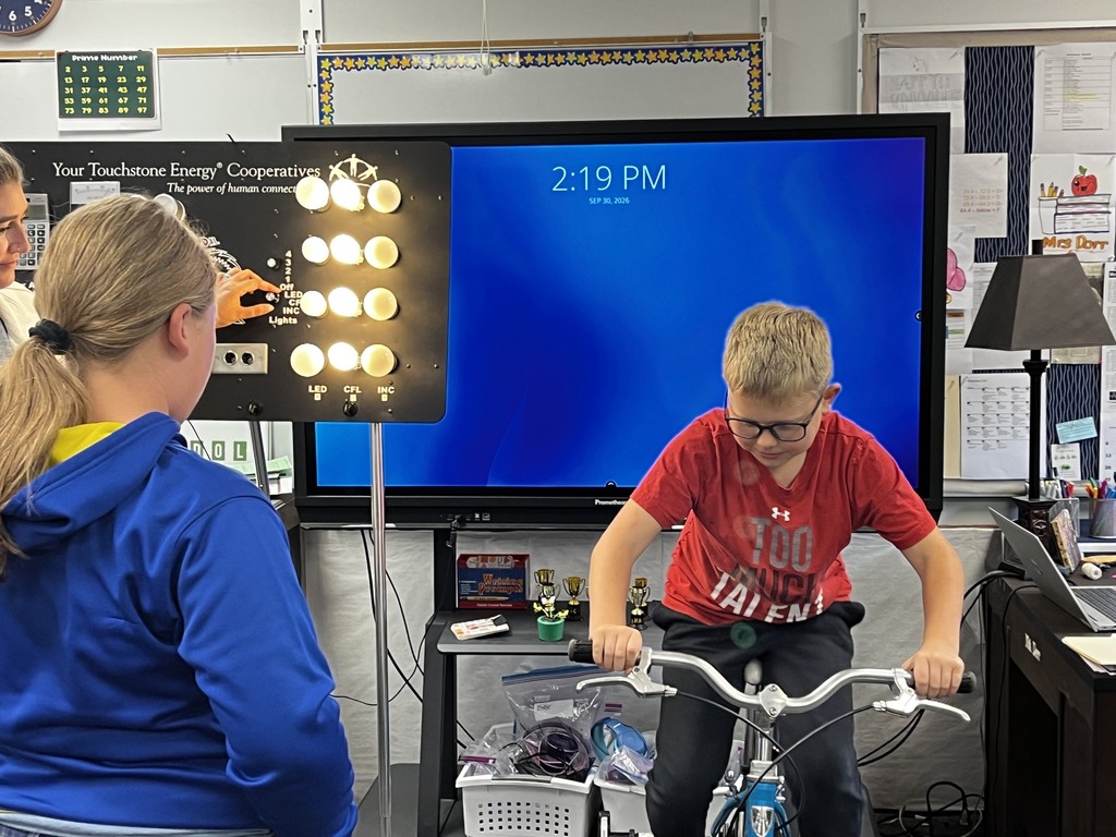 Riding the bicycle to generate electricity to light the bulbs.