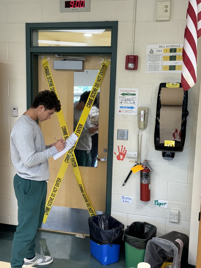 Student standing at a door with yellow caution tape and a red handprint