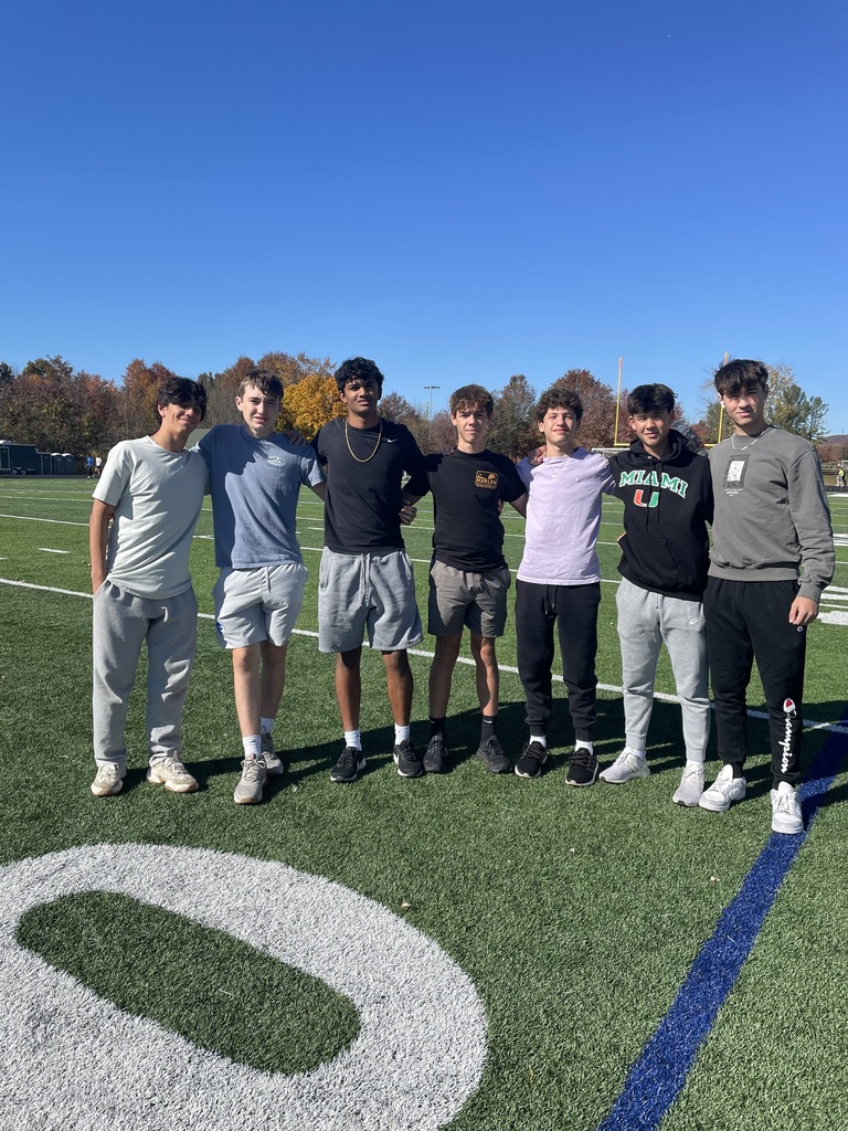 7 students pose outside on the football field
