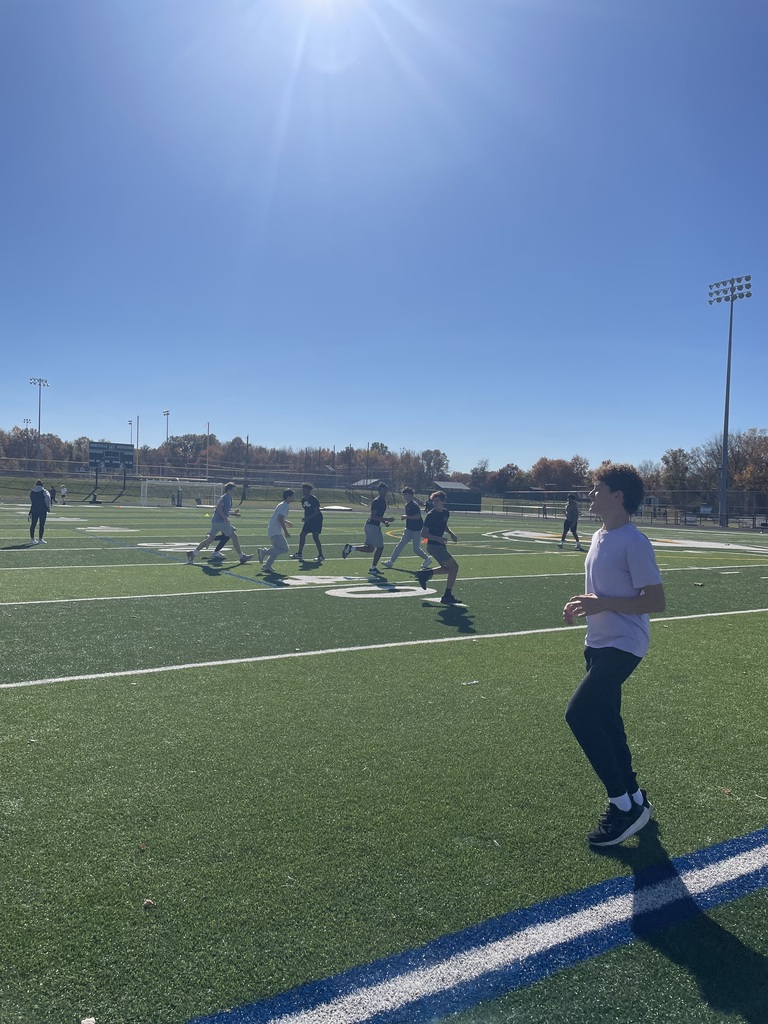 students scatter on the football field in anticipation of a pass
