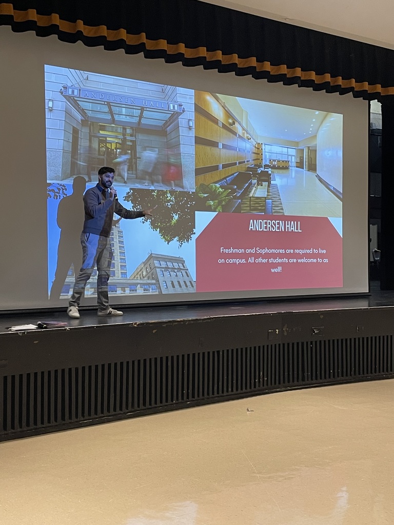 Kameron Ghanavati, Assistant Director of Admissions at the Manhattan College of Music, presents to students. The current slide behind him reads "Andersen Hall" and disucsses on campus housing available.
