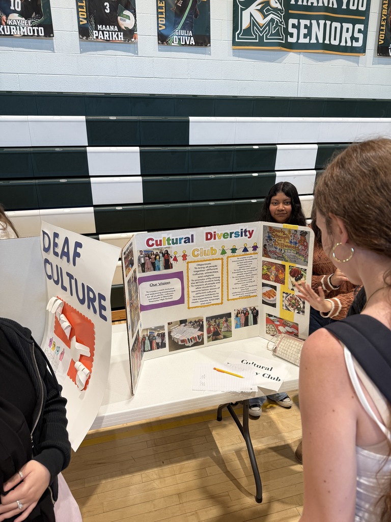 students take a look at the Cultural Diversity Club trifold during the annual club fair
