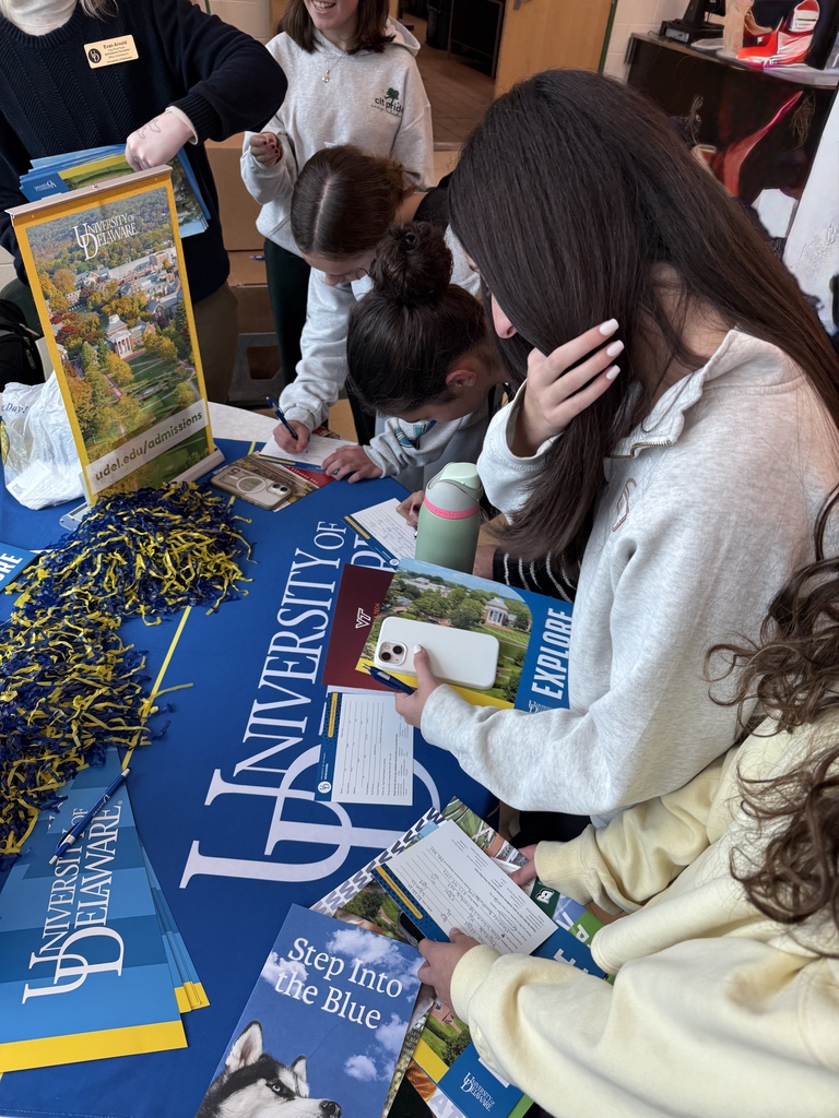 Several students visit the University of Delaware college fair table.