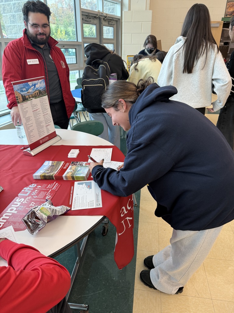 Student fills out information card at the Sacred Heart University table at the high school college fair. 