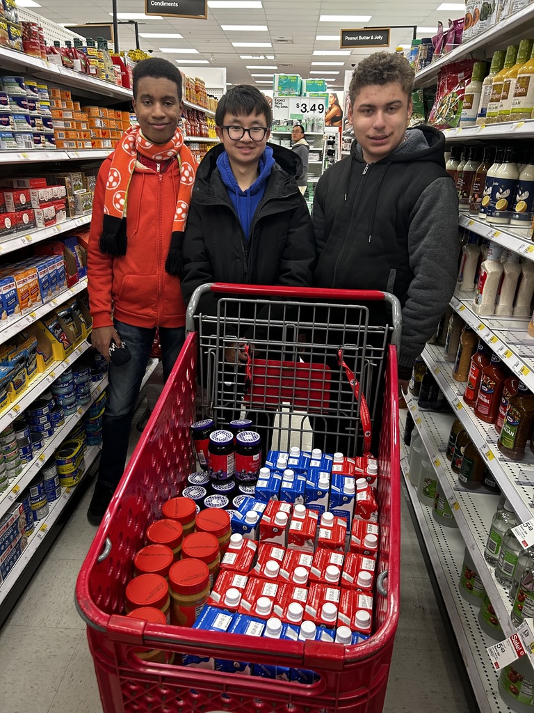Three students in the ACCE program went shopping for the food drive yesterday. The picture shows the students and their cart full of shelf stable milk, peanut butter and jelly