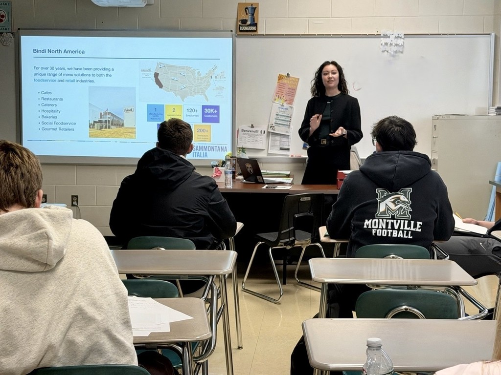 Presenter stands in front of class presenting information related to their company, Bindi North America.