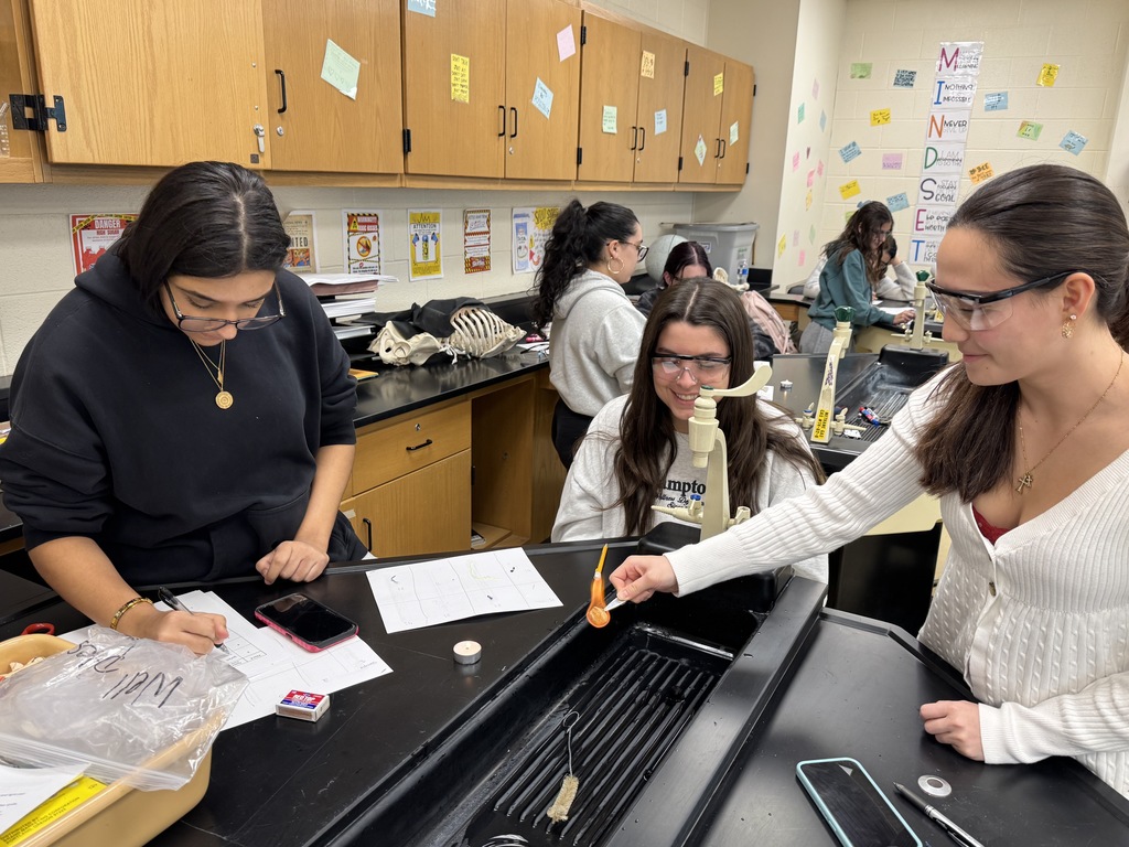 Students in forensic science wearing lab safety goggles and burning fibers 