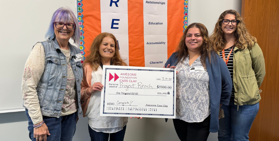 Vian Mustafa receives a $1000 check from the Awesome Foundation