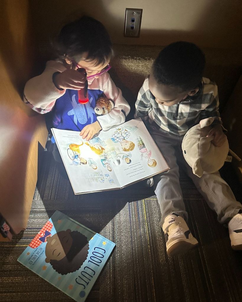 Students in Brooklynn and Katie's class reading in the dark with flashlights.