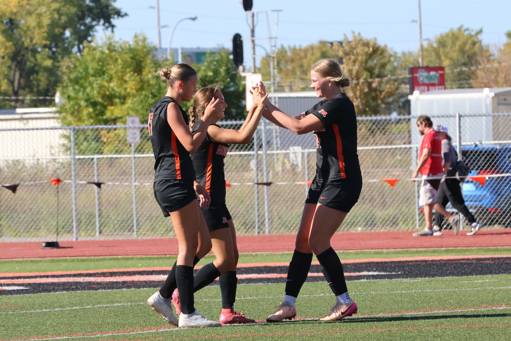 "Ashlann Haneca, Quinn Erickson, and Reese Astrup celebrate during the Moorhead girls soccer match
