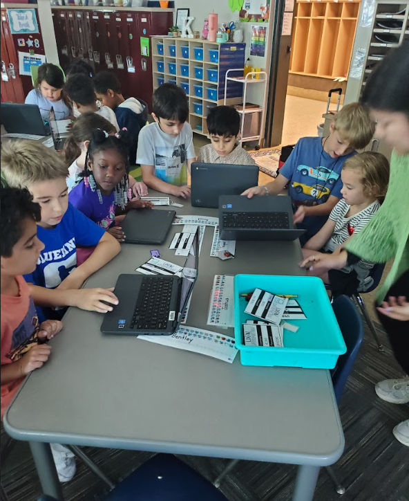 Third Grade helping Kindergarteners log into chromebook