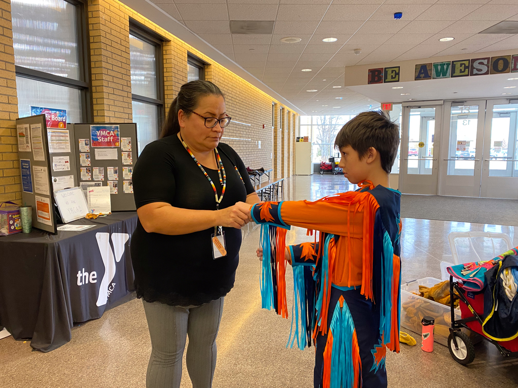 Delores Gabbard helps a dancer with his traditional outfit at SGR