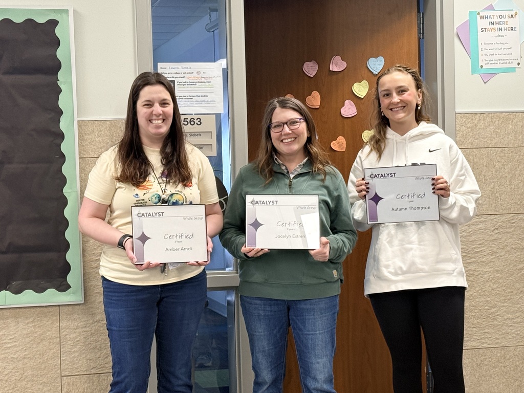 Three teachers holding their frames of certificates