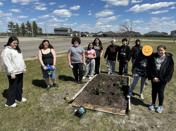 Students standing in front of a garden 