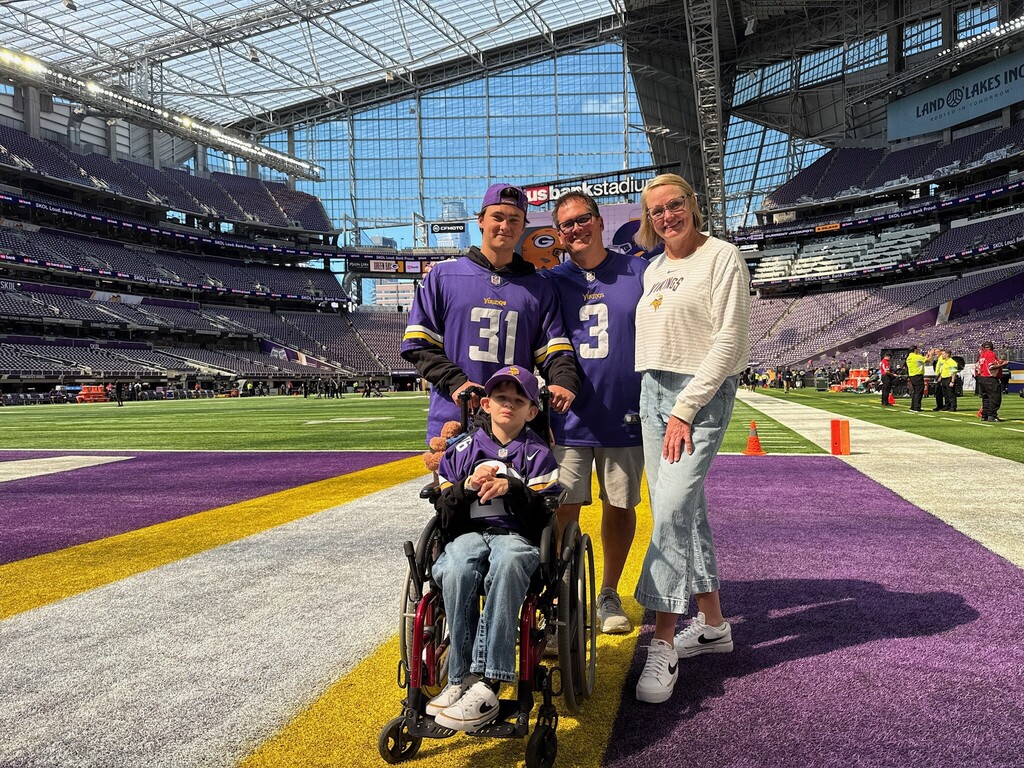 Student on the field with his family at the vikings game