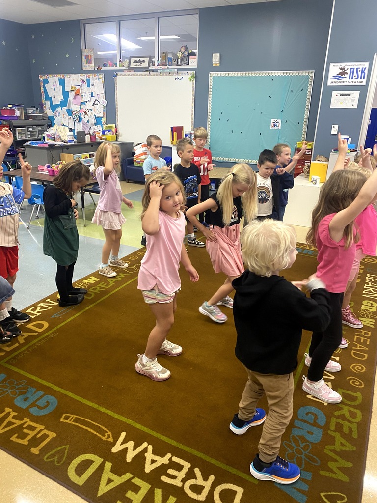 A group of students dancing in the classroom. 