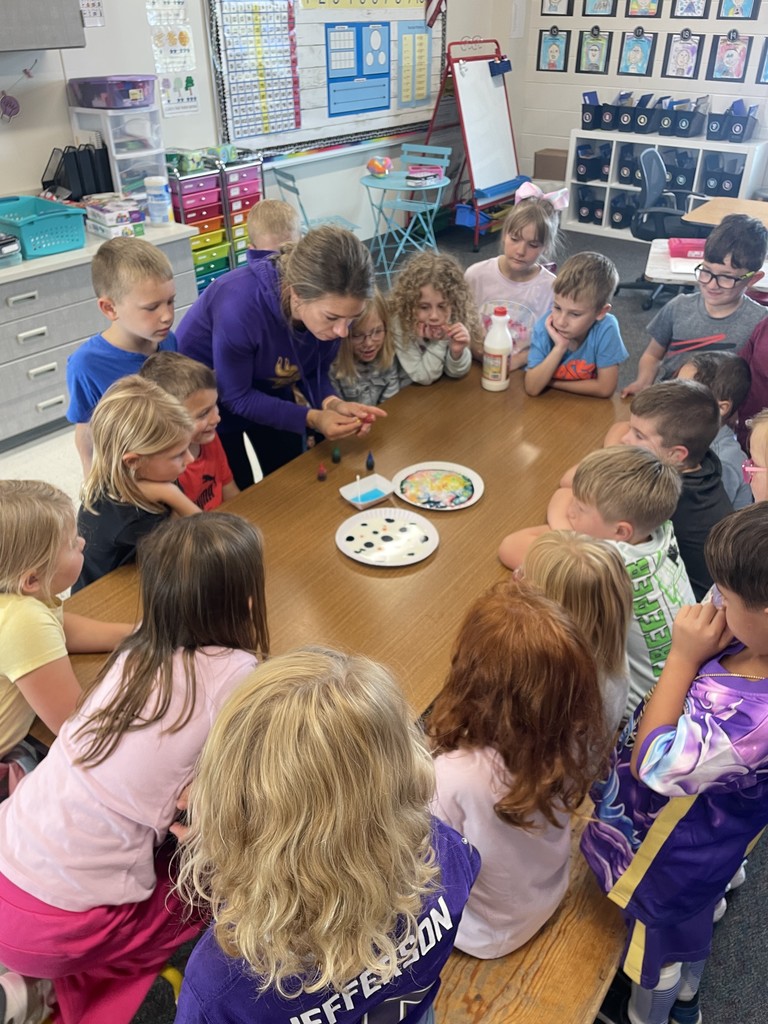 Ms Hambly is setting up the magic milk experiment while students watch.