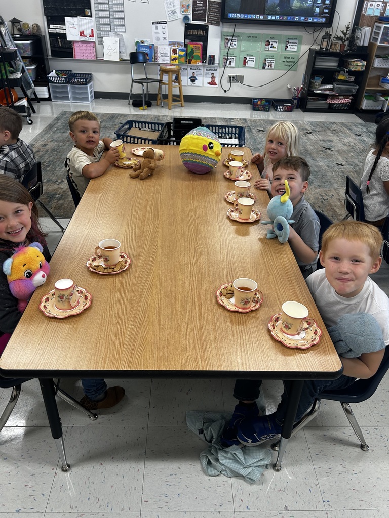 A group of 5 students enjoying the tea party at their table.