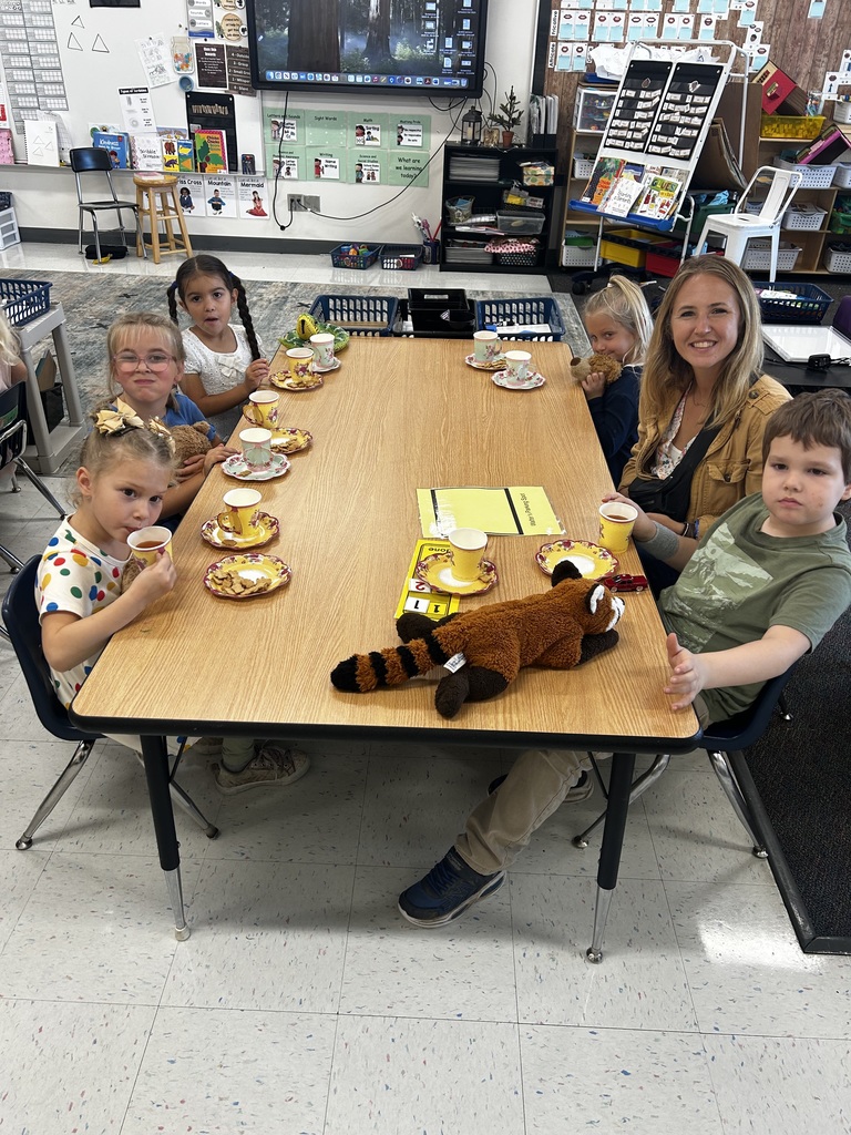 Students and a staff member smiling and enjoying the tea party.