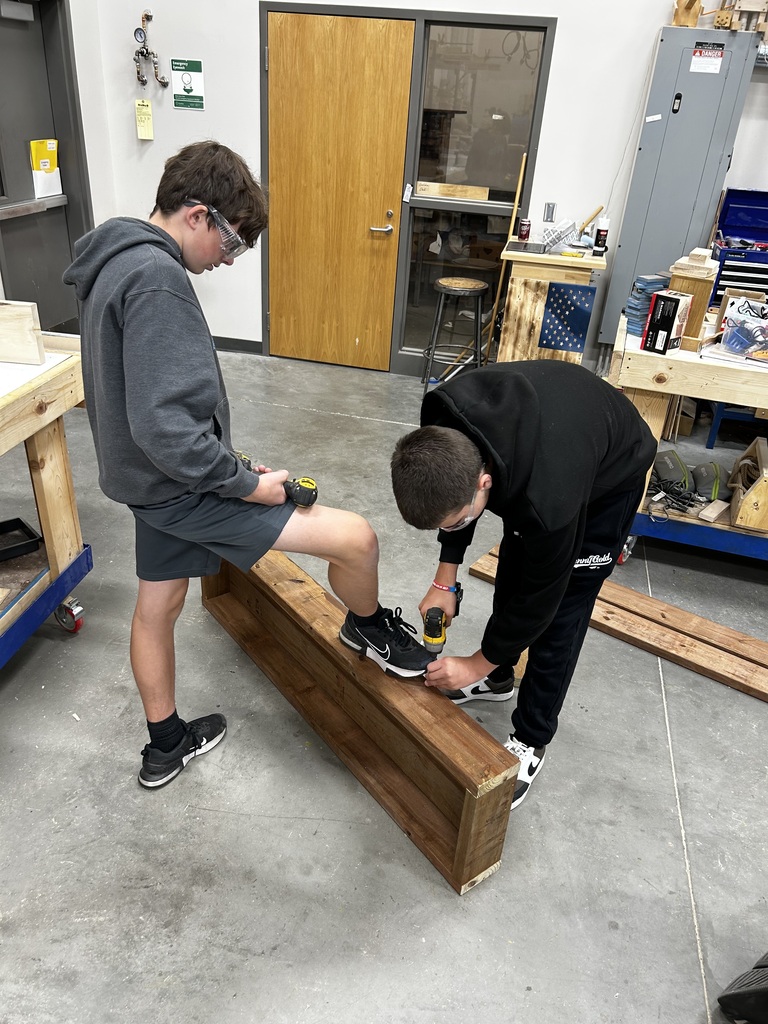 Shop students crafting new bench tops for the outdoor classroom.
