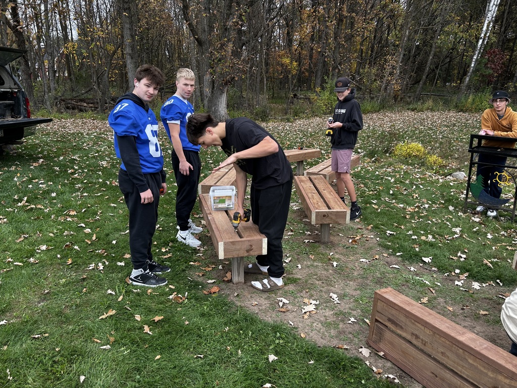 Shop students crafting new bench tops for the outdoor classroom.