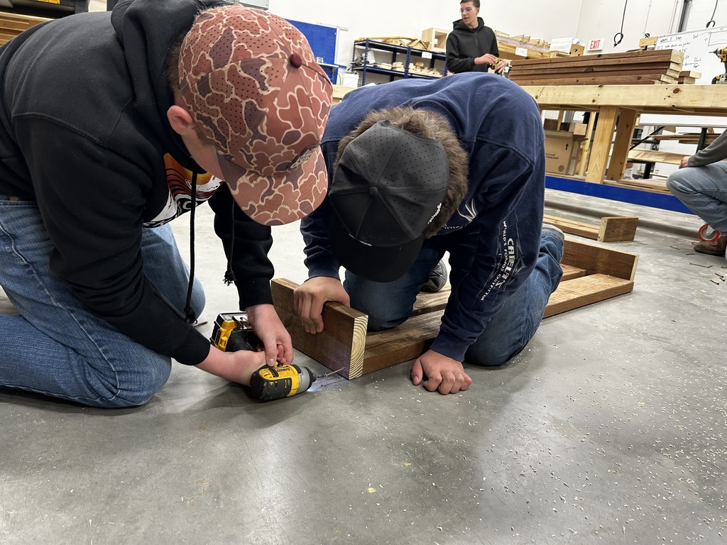 Shop students crafting new bench tops for the outdoor classroom.