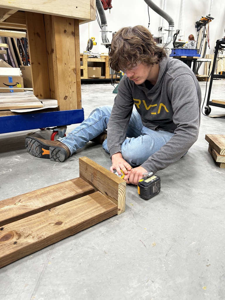 Shop students crafting new bench tops for the outdoor classroom.