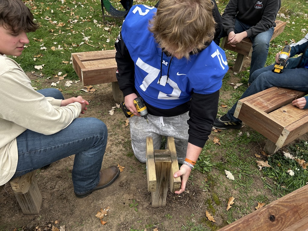 Shop students crafting new bench tops for the outdoor classroom.