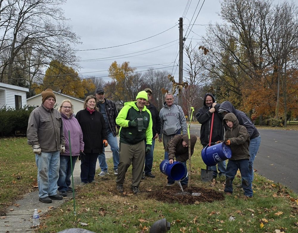 PHoto of group planting and watering tree