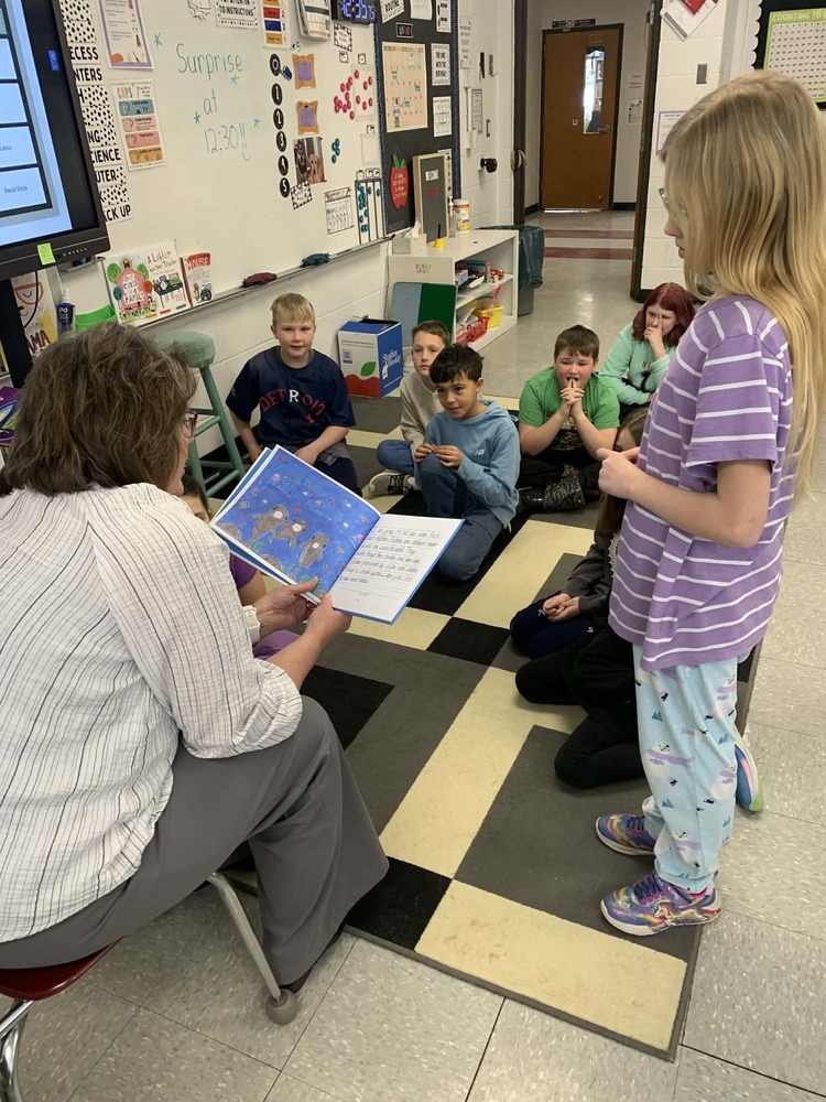 Principal reading a book to the class.