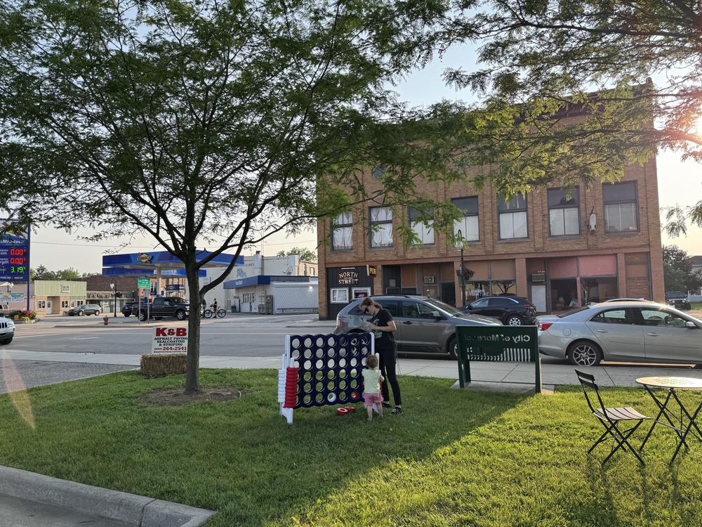 mom and child playing connect 4 on lawn